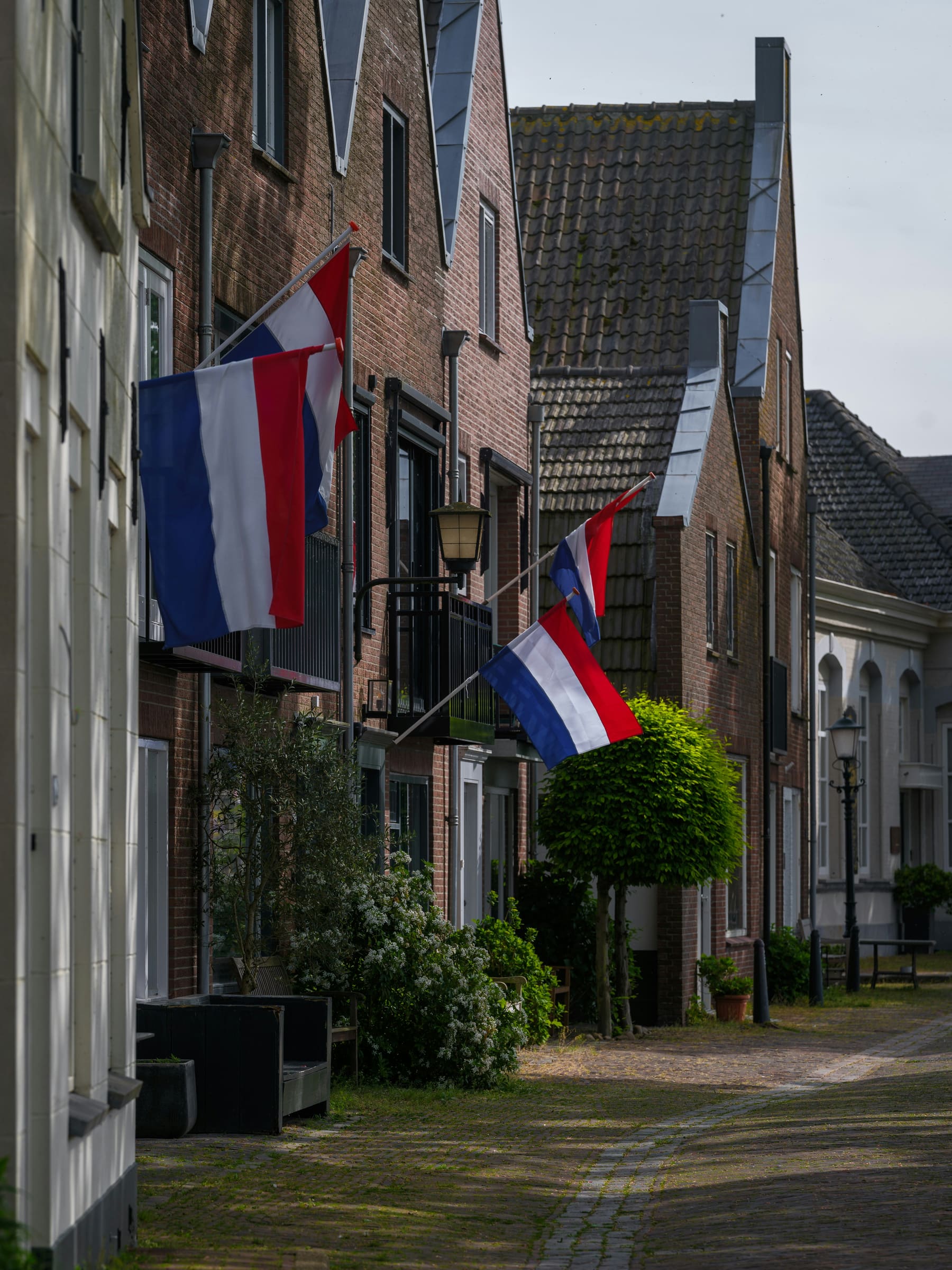 Nederlandse dorpsstraat met uitgehangen vlaggen
