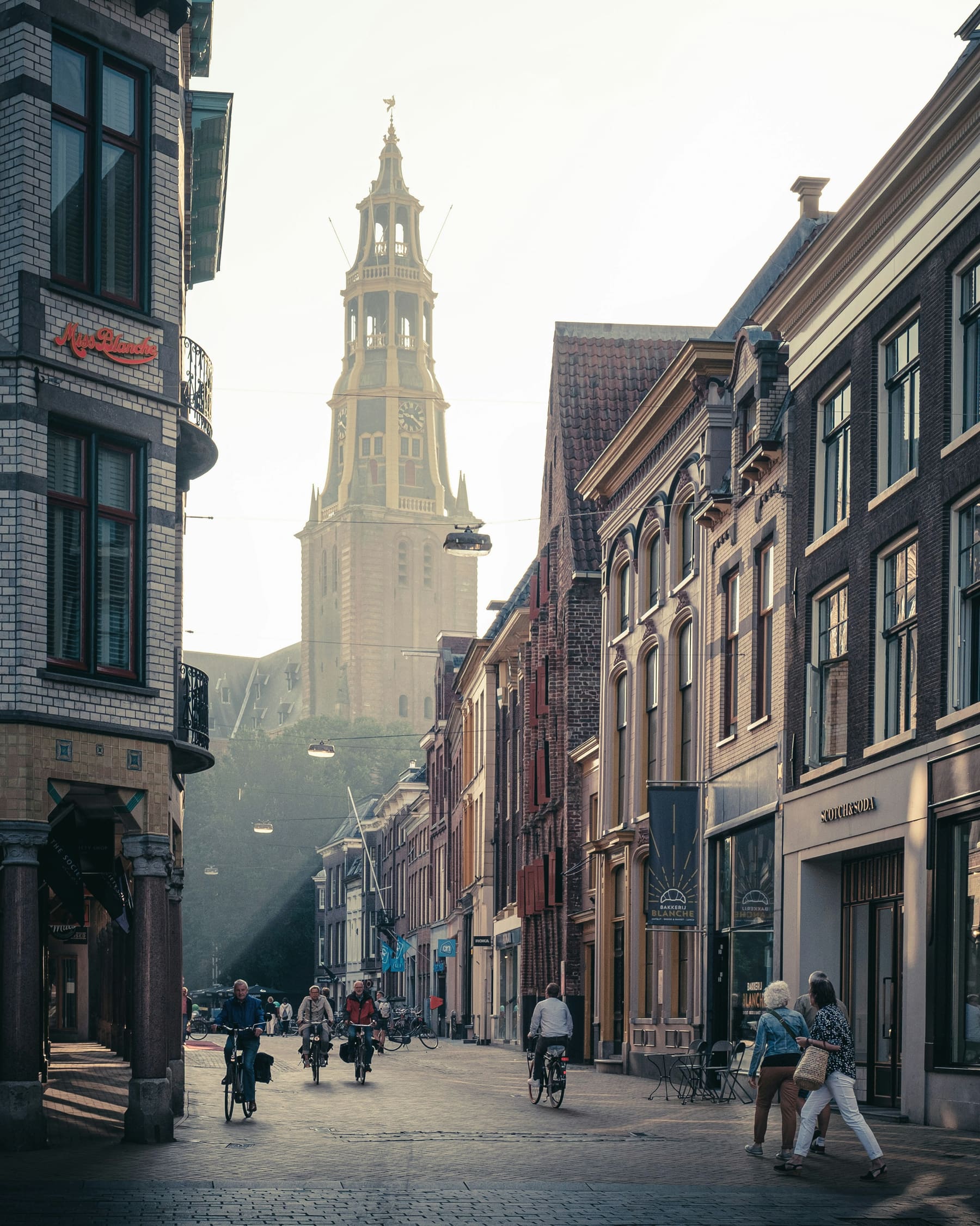 Fietsers op een historische straat in Groningen tijdens het gouden uur
